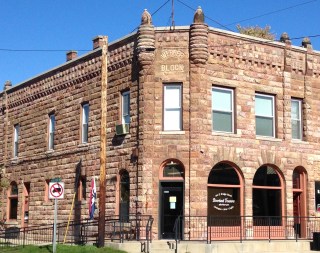 Photo of the Webber bank building in Lyons, Michigan with Riverbank Treasures sign in the window.